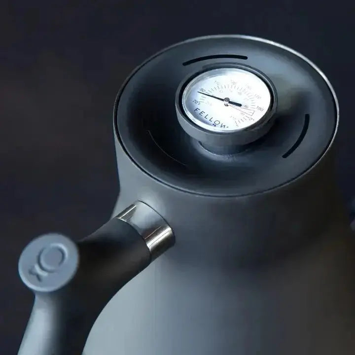 Matte black stovetop kettle with built-in temperature gauge on lid by Fellow